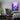 A gaming room, featuring a purple rainy city canvas hanging as wall decor.