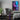 A gaming room featuring the neon city wall art hanging next to a gaming computer setup as decor.